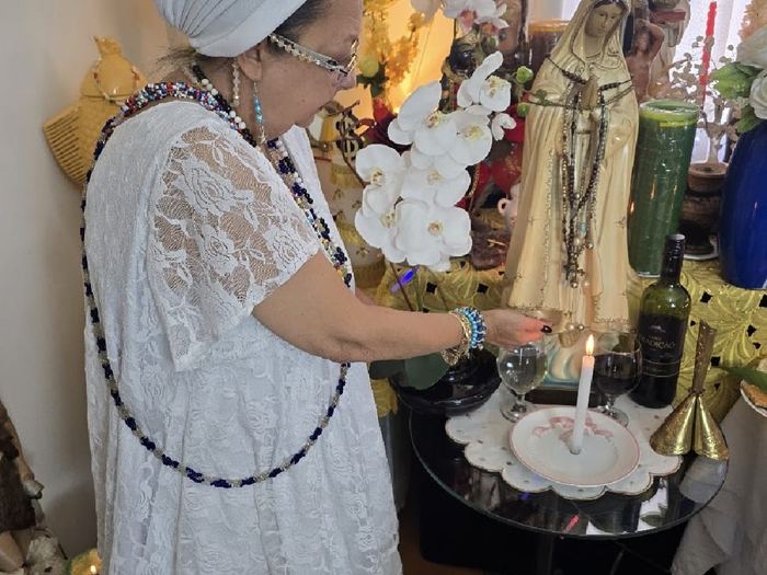 Altar espiritual com velas e flores usado nos trabalhos de Mãe Dalva