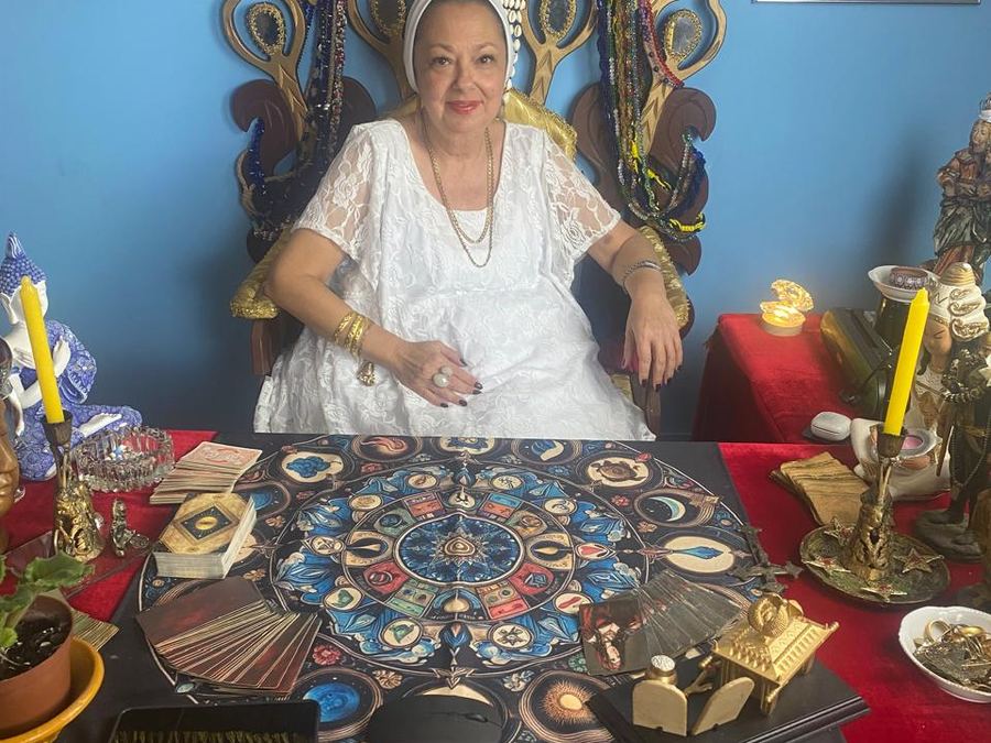 Espaço de atendimento de Mãe Dalva, com mesa de tarot e búzios