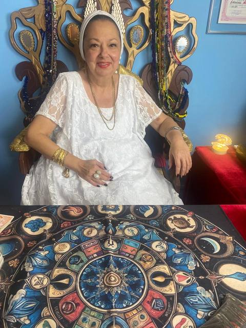 Mãe Dalva sentada ao trono, com a toalha do tarot sobre a mesa