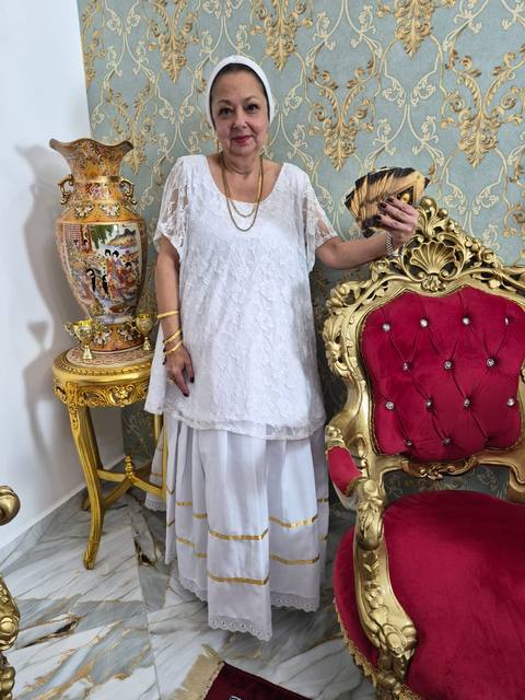 Mãe Dalva com leque dourado e cartas de tarot