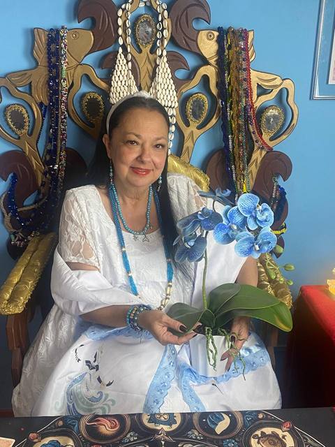 Mãe Dalva em momento de contemplação, vestida de azul-claro