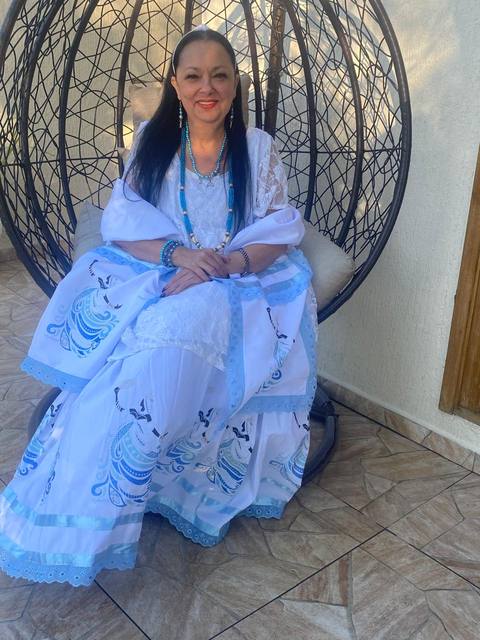Mãe Dalva junto ao altar de Nossa Senhora e às imagens de fé