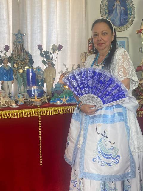 Mãe Dalva com leque dourado, pronta para a consulta de tarot