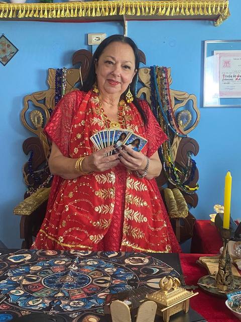 Mãe Dalva com o baralho de tarot, no trono de atendimento