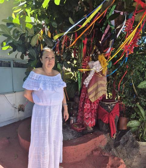 Mãe Dalva junto à imagem sagrada, com incenso e oferendas
