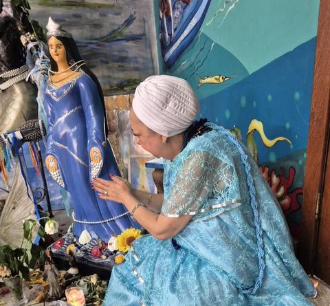 Mãe Dalva em oração diante da imagem de Iemanjá