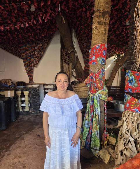 Mãe Dalva em vestido branco, em ambiente de jardim