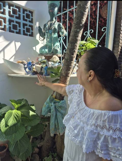 Mãe Dalva junto à estátua de Iemanjá no jardim